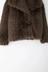Gros plan sur la texture de fausse fourrure brune épaisse d'une veste de luxe pour femme