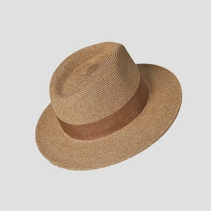 Close-up of natural straw boater hat featuring a brown grosgrain ribbon and fine weave texture
