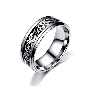 Macro view of stainless steel ring featuring intricate silver Celtic dragon pattern inlay