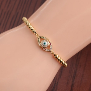 Detailed shot of gold evil eye bracelet with multi-color zircon stones and beads