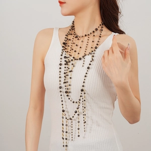 Close-up of black glass beads and gold chains on layered tassel statement necklace