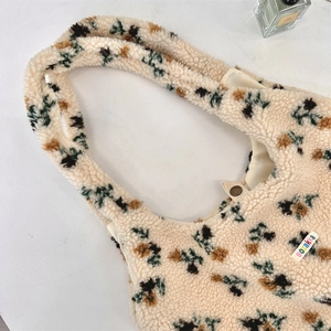 Detail of lamb wool tote bag with floral patterns and secure magnetic metal snap closure