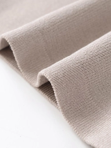 Macro shot of soft oatmeal ribbed knit fabric texture on long sleeve sweatshirt