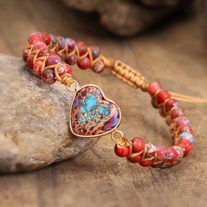 Macro shot of boho multilayer woven wrap bracelet with heart-shaped stone pendant