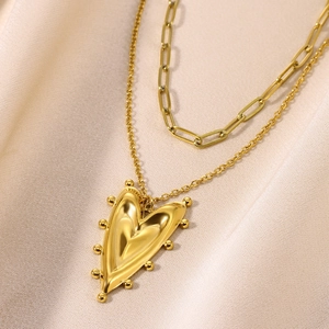 Detail of 18K gold stainless steel layered necklace with 3D heart pendant on velvet