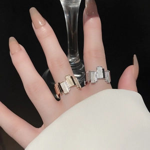 Detailed close-up of gold and silver geometric zircon rings worn on fingers