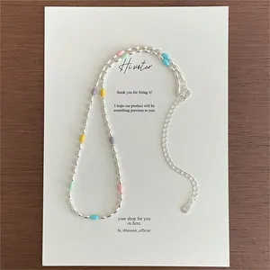 Macro detail of S925 sterling silver stamp on rainbow bead necklace with lobster clasp