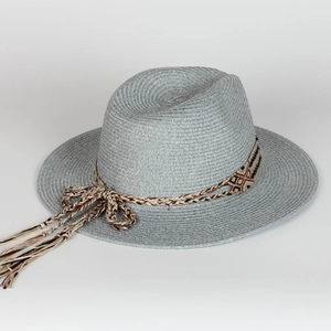 Detailed weave of a blue straw sun hat with ethnic patterned band and tassel detail