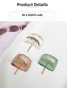 Detail view of U-shaped resin hair pins in pink, green, and clear with gold accents