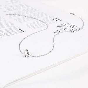 Close-up of polished silver boy pendant necklace on a fashion magazine background