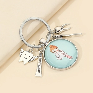 Creative dental keychain with tooth, toothpaste, and toothbrush charms on a light background