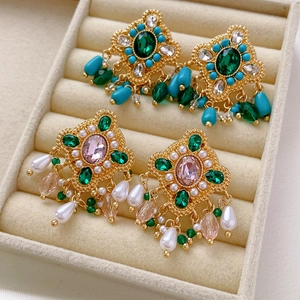Vue détaillée de boucles d'oreilles vintage avec perles et diamants dans un coffret beige