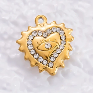 Golden heart pendant with devil eye design and white zircon stones in macro view