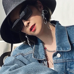 Silver bow streamer earrings and beaded necklace styled with black sunglasses