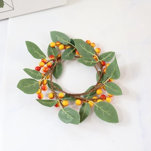 Autumn candle ring with artificial orange berries and green leaves for festive decor