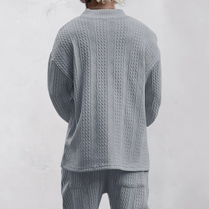 Detailed back view of light gray knitted sweater with diamond cable patterns