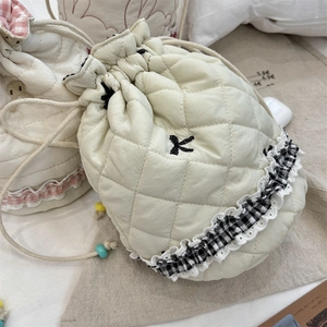 Quilted cream drawstring bag detail with rhombus pattern, beads and lace trim