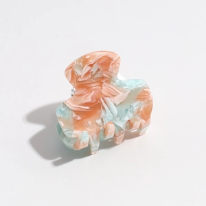 Detail of mint green and pink marble pattern hair claw clip with glossy finish