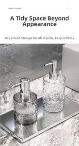 Detail of luxury hammer-textured glass soap dispensers on a sleek metal tray in a bathroom
