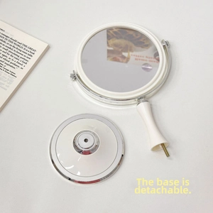 Detail view of the detachable round white vanity mirror showing the base and screw assembly