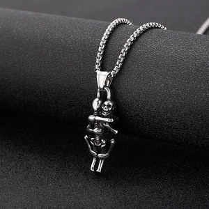 Macro shot of vintage stainless steel twin skeletons embracing sword pendant necklace