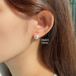 Close-up of a 10mm cream rose pearl earring worn on ear with soft lustrous texture
