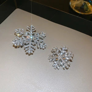 Macro shot of silver snowflake hair clips with sparkling rhinestones set on a gray tray