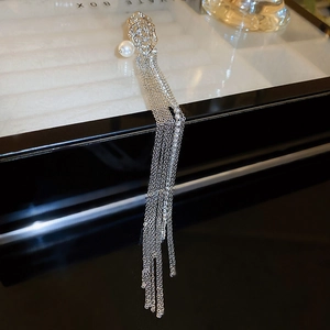 Detail of silver rose earring with long metal tassel chains and white round pearls
