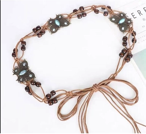 Close-up of bohemian waist chain with bronze butterflies and blue resin gemstones