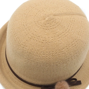 Detailed close-up of beige knit hat showing intricate spiral weave and texture