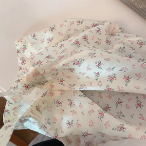 Detalle de cerca del bolso de algodón crema con un elegante estampado floral rosa