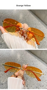 Detailed view of trendy rimless oval orange yellow sunglasses with gold metal temples