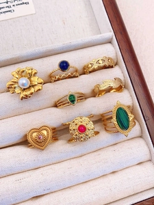Detail of 8-piece vintage gold-tone ring set with gemstones and pearls in jewelry box