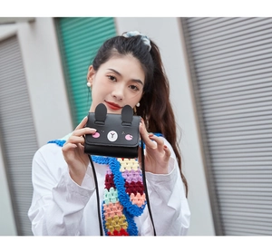 Close-up of small black PU leather crossbody bag featuring cute cartoon rabbit design
