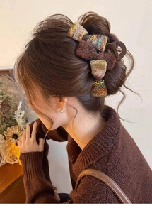Pince à cheveux noeud en tweed marron avec texture vintage montrée portée sur les cheveux