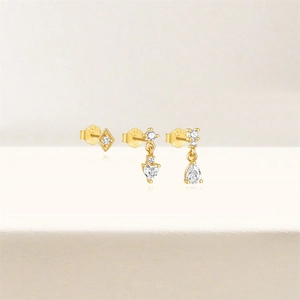 Detail shot of golden S925 sterling silver earrings set with zircon heart and drop shapes