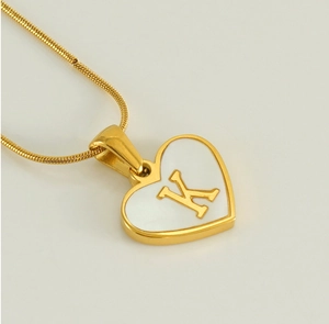 Macro view of the gold 18K stainless steel heart pendant with white shell and letter K