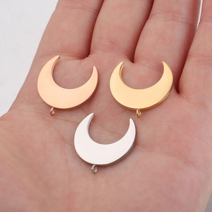 Three crescent moon pendants in gold, rose gold and silver finish held in hand