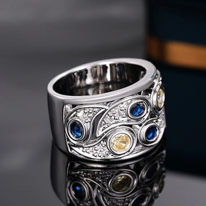 Détail macro de bague large en argent avec pierres bleues et gravure florale évidée vintage