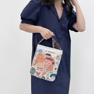 Detail of bohemian canvas bag featuring colorful elephant embroidery and ethnic woven strap