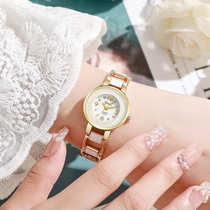 Primo piano di un elegante orologio al quarzo in ceramica e oro indossato da una donna