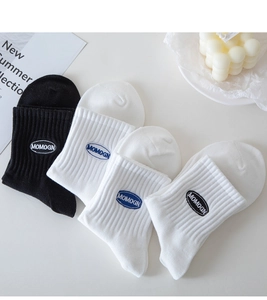 Flat lay of cotton crew socks in black and white with premium MOMOGN logo embroidery