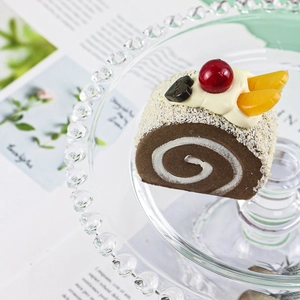 Macro detail of chocolate swiss roll cake model with heart LOVE topper and cherry décor
