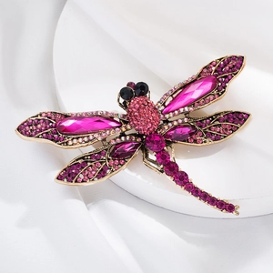 Close-up of vintage dragonfly brooch with rose red and purple crystal rhinestones