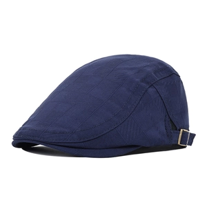 Detail of navy flat cap with square texture and vintage bronze metal buckle