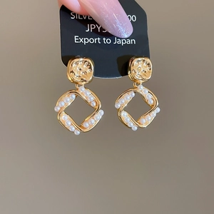 Macro detail of vintage hammered gold square earrings with inlaid pearls and S925 silver pins