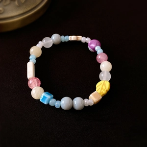 Makro-Detail bunter Keramikperlen und Elefantenanhänger Armband auf dunklem Grund