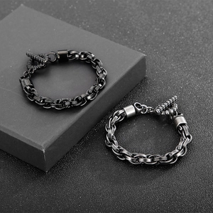 Détail de bracelets chaîne tête de mort argent et noir avec fermoir OT sur boîte cadeau