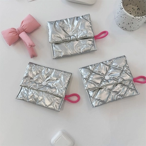 Detailed macro view of quilted silver metallic makeup pouches with pink lanyards and bows