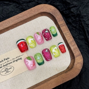 Handmade fruit-themed press-on nails with 3D water drops and vibrant summer cat-eye patterns